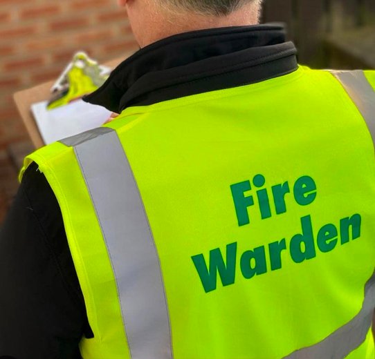 Fire warden attire including a high-visibility yellow jacket, protective helmet, and durable boots for effective emergency response.