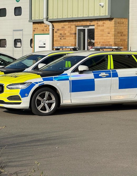 A pair of police vehicles parked adjacent to each other, highlighting their official insignia and design.